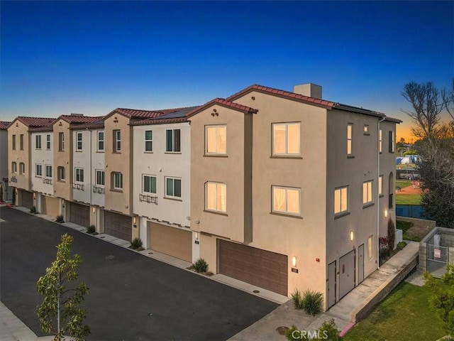 2750 182nd St Unit 112, Torrance, CA 90504 - property at dusk featuring a garage and driveway