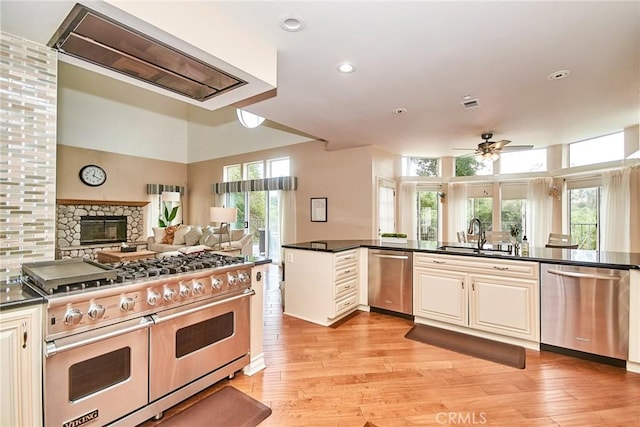 1089 Village Dr, Chino Hills, CA 91709 - kitchen featuring appliances with stainless steel finishes, a sink, ceiling fan, dark countertops, and light wood finished floors