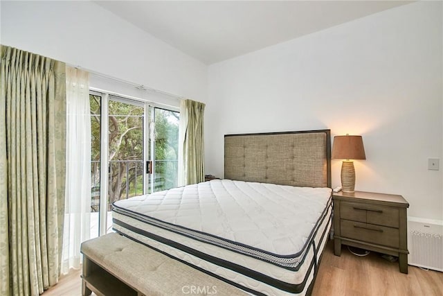 1089 Village Dr, Chino Hills, CA 91709 - bedroom with wood finished floors, access to exterior, and radiator heating unit