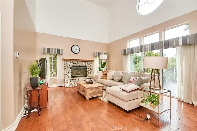 1089 Village Dr, Chino Hills, CA 91709 - living room with a towering ceiling, wood-type flooring, a stone fireplace, and plenty of natural light