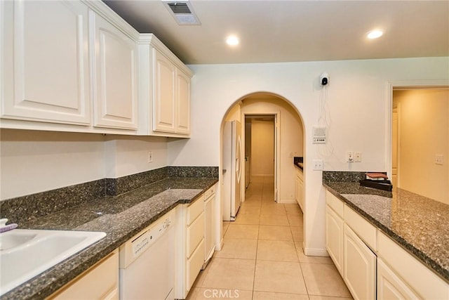 1089 Village Dr, Chino Hills, CA 91709 - kitchen featuring dishwasher, arched walkways, light tile patterned floors, a sink, and dark stone countertops