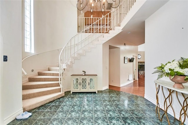 1089 Village Dr, Chino Hills, CA 91709 - staircase with a high ceiling, a chandelier, baseboards, and tile patterned floors