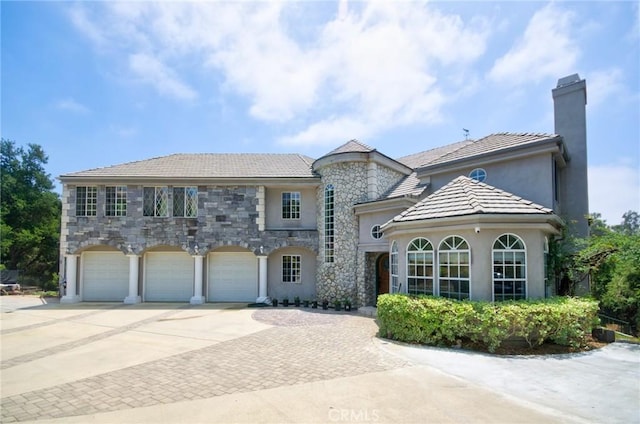 1089 Village Dr, Chino Hills, CA 91709 - view of front of home featuring concrete driveway, a garage, stucco siding, stone siding, and a chimney