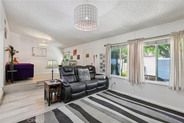 10161 Larwin Ave Unit 3, Chatsworth, CA 91311 - living room with a textured ceiling, wood finished floors, baseboards, and a chandelier