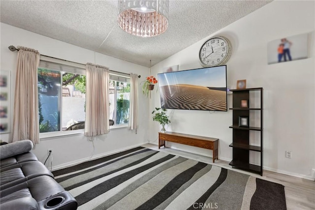 10161 Larwin Ave Unit 3, Chatsworth, CA 91311 - living room featuring a textured ceiling, a chandelier, wood finished floors, and baseboards