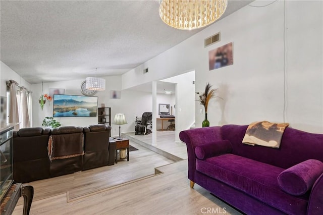 10161 Larwin Ave Unit 3, Chatsworth, CA 91311 - living room with a chandelier, wood finished floors, and a textured ceiling