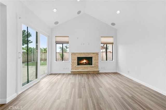10991 Countryview Dr, Rancho Cucamonga, CA 91730 - unfurnished living room with vaulted ceiling, a warm lit fireplace, light wood-type flooring, baseboards, and recessed lighting