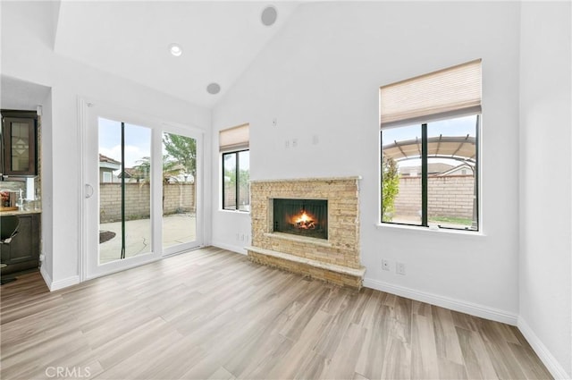 10991 Countryview Dr, Rancho Cucamonga, CA 91730 - unfurnished living room with plenty of natural light, high vaulted ceiling, a fireplace, wood finished floors, and baseboards