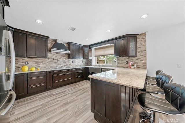 10991 Countryview Dr, Rancho Cucamonga, CA 91730 - kitchen featuring wall chimney exhaust hood, a peninsula, dark brown cabinets, and recessed lighting