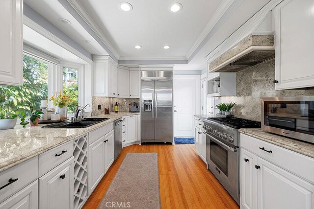 1609 Via Montemar, Palos Verdes Estates, CA 90274 - kitchen featuring high end appliances, white cabinetry, ornamental molding, backsplash, and light wood-style floors
