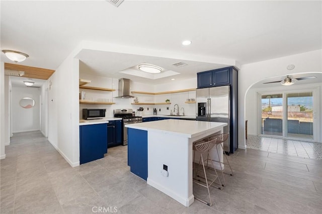 72726 Desert Trail Dr Unit 29, Palms, CA 92277 - kitchen with stainless steel appliances, blue cabinets, island exhaust hood, open shelves, and a sink