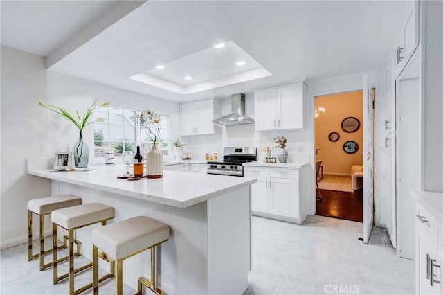 1717 Morning Sun Ave, Walnut, CA 91789 - kitchen with stainless steel range with electric stovetop, wall chimney range hood, a breakfast bar, a peninsula, and light countertops