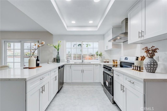 1717 Morning Sun Ave, Walnut, CA 91789 - kitchen with stainless steel appliances, wall chimney range hood, a peninsula, healthy amount of natural light, and recessed lighting