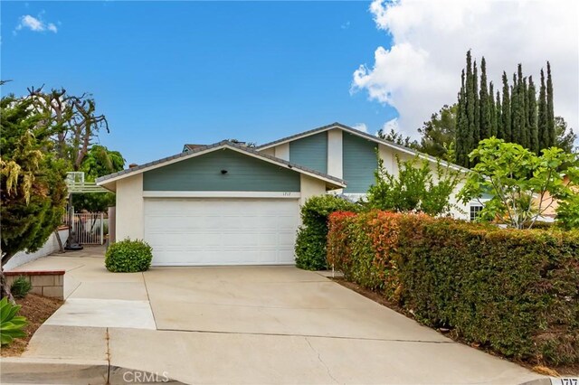 1717 Morning Sun Ave, Walnut, CA 91789 - view of front facade with a garage, concrete driveway, and a gate