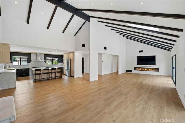 4801 Heaven Ave, Woodland Hills, CA 91364 - living room featuring high vaulted ceiling, beam ceiling, light wood-type flooring, and a lit fireplace