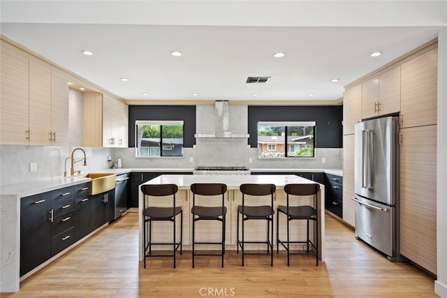 4801 Heaven Ave, Woodland Hills, CA 91364 - kitchen with wall chimney exhaust hood, stainless steel appliances, a sink, a breakfast bar, and light countertops
