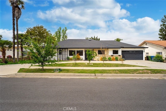 4801 Heaven Ave, Woodland Hills, CA 91364 - ranch-style house with driveway, an attached garage, a front lawn, and stone siding