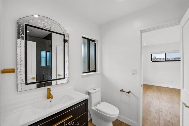 4801 Heaven Ave, Woodland Hills, CA 91364 - bathroom featuring vanity, toilet, wood finished floors, and baseboards