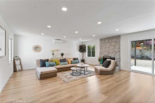 17924 E Kelby St, Covina, CA 91722 - living room with an AC wall unit, light wood-style flooring, recessed lighting, and a fireplace