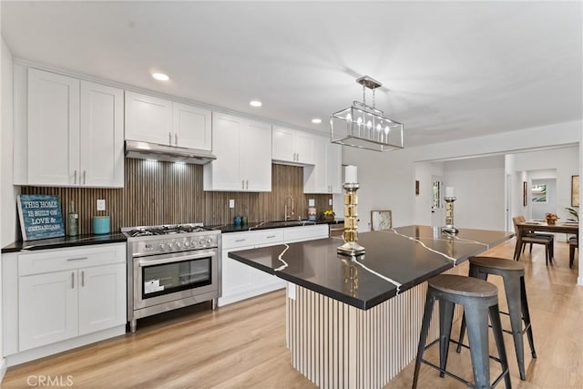 17924 E Kelby St, Covina, CA 91722 - kitchen with stainless steel range, under cabinet range hood, light wood-type flooring, white cabinets, and recessed lighting