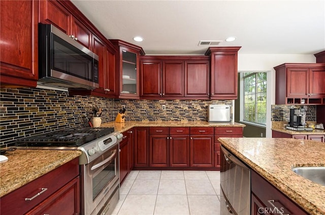 178 Grapevine Dr, Corona, CA 92882 - kitchen featuring stainless steel appliances, dark brown cabinets, light stone countertops, and recessed lighting