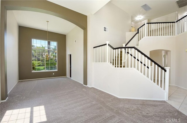 178 Grapevine Dr, Corona, CA 92882 - stairs with arched walkways, carpet, baseboards, and a towering ceiling