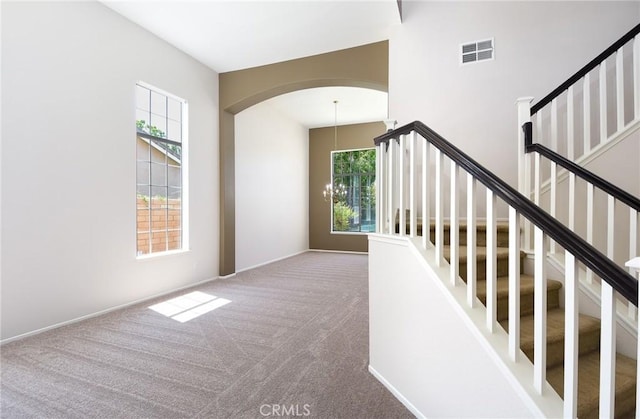 178 Grapevine Dr, Corona, CA 92882 - staircase with carpet flooring, a chandelier, and arched walkways
