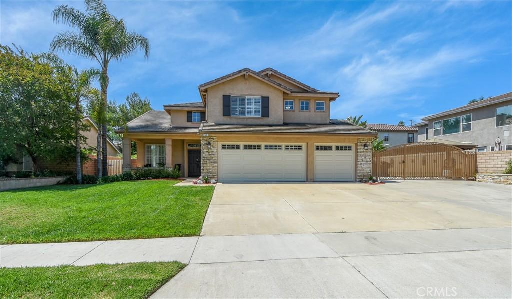 178 Grapevine Dr, Corona, CA 92882 - view of front of home featuring a garage, stucco siding, driveway, and a gate
