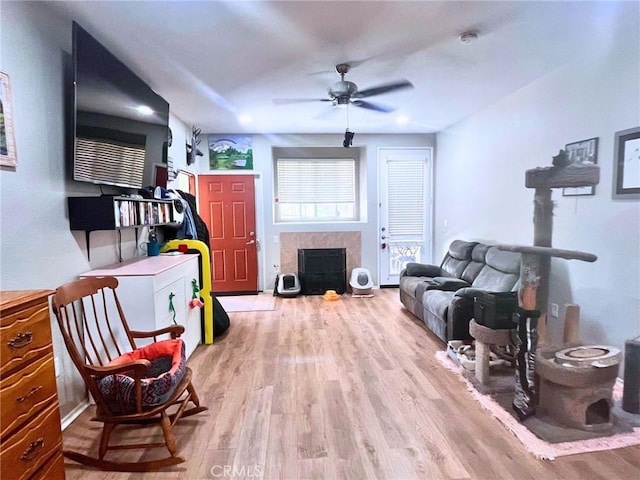 41410 Juniper St Unit 1513, Murrieta, CA 92562 - living area featuring a fireplace with flush hearth, light wood-style flooring, and ceiling fan