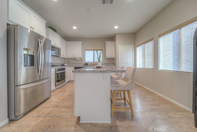 32593 Cumulus Ln, Winchester, CA 92596 - kitchen featuring stainless steel appliances, baseboards, white cabinetry, a breakfast bar, and recessed lighting