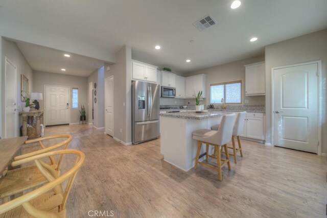 32593 Cumulus Ln, Winchester, CA 92596 - kitchen with appliances with stainless steel finishes, a center island, white cabinetry, recessed lighting, and light wood finished floors