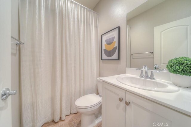 32593 Cumulus Ln, Winchester, CA 92596 - bathroom featuring vanity, toilet, curtained shower, and wood finished floors