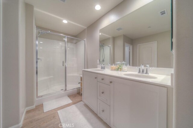 32593 Cumulus Ln, Winchester, CA 92596 - full bathroom featuring wood finished floors, double vanity, a shower stall, and recessed lighting