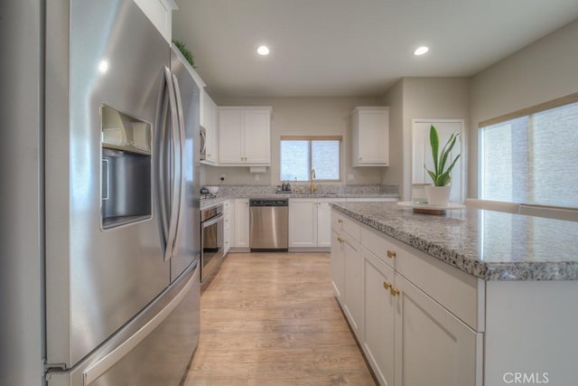 32593 Cumulus Ln, Winchester, CA 92596 - kitchen with stainless steel appliances, white cabinets, light wood-type flooring, recessed lighting, and light stone countertops