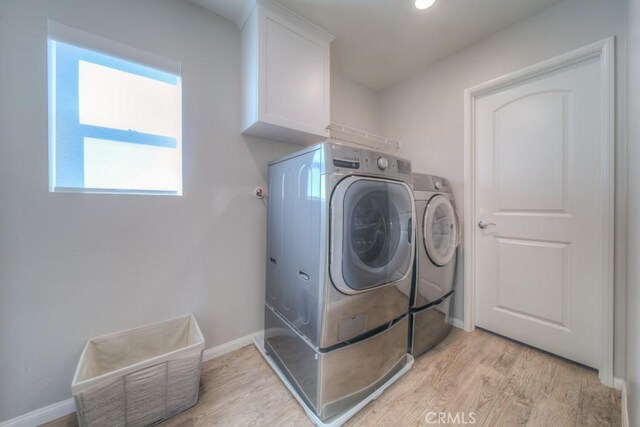 32593 Cumulus Ln, Winchester, CA 92596 - washroom with washing machine and clothes dryer, light wood-type flooring, baseboards, and cabinet space