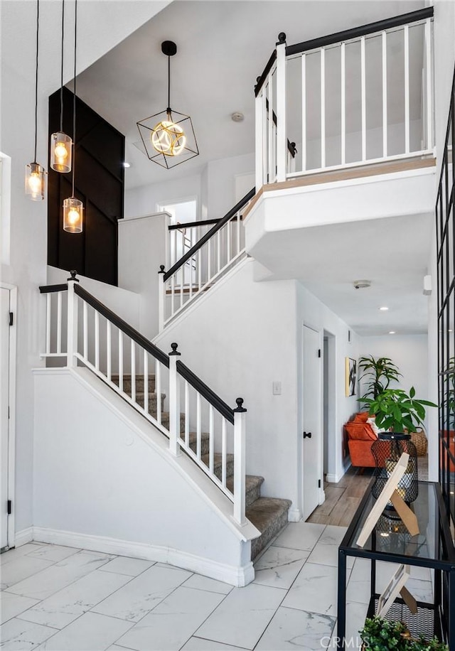 13492 Palomino Creek Dr, Corona, CA 92883 - staircase with marble look tiles, a high ceiling, and recessed lighting
