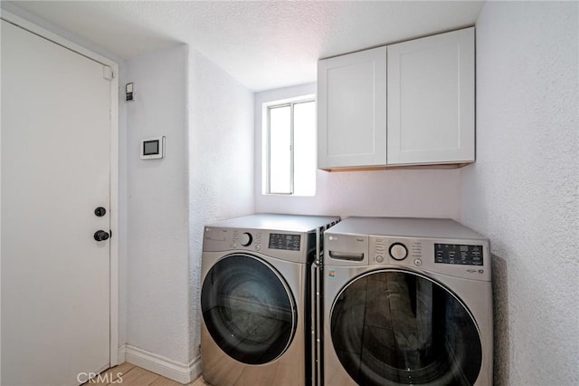 13492 Palomino Creek Dr, Corona, CA 92883 - laundry room featuring washer and dryer, cabinet space, a textured ceiling, and a textured wall