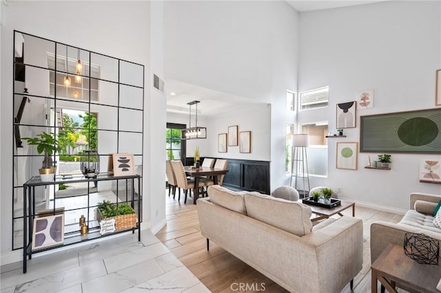 13492 Palomino Creek Dr, Corona, CA 92883 - living room featuring a towering ceiling, a chandelier, and marble finish flooring