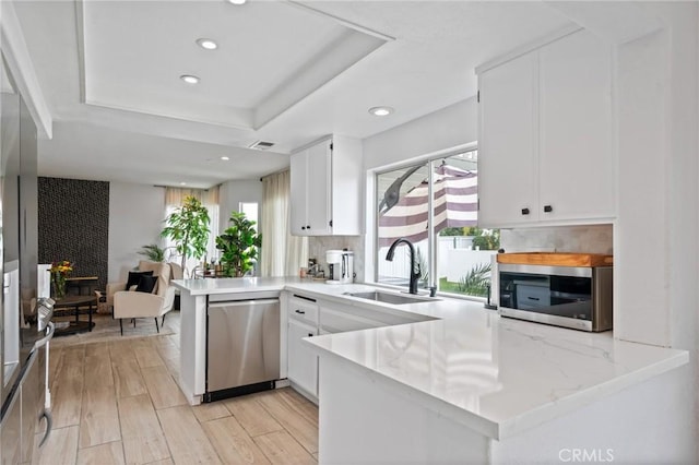 13492 Palomino Creek Dr, Corona, CA 92883 - kitchen with stainless steel appliances, a peninsula, healthy amount of natural light, white cabinets, and recessed lighting