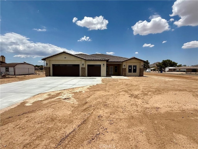 15640 Cheyenne Rd, Apple Valley, CA 92307 - view of front of property with an attached garage, driveway, a tile roof, stone siding, and stucco siding
