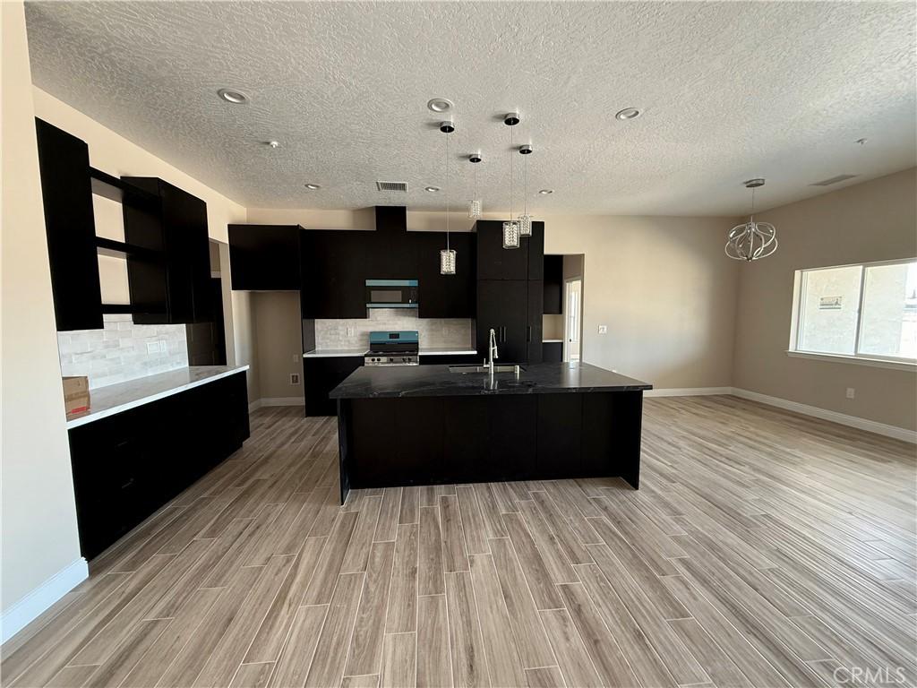 15640 Cheyenne Rd, Apple Valley, CA 92307 - kitchen with dark cabinetry, range, modern cabinets, a sink, and a textured ceiling