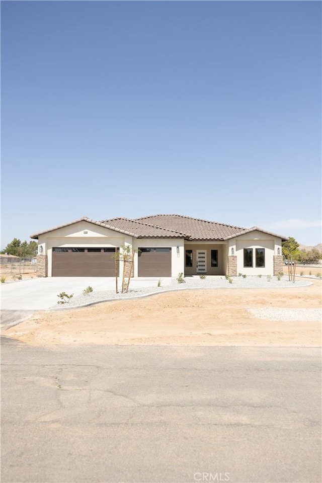 15640 Cheyenne Rd, Apple Valley, CA 92307 - view of front of home featuring concrete driveway, a garage, stucco siding, and a tiled roof
