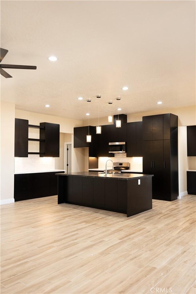 15640 Cheyenne Rd, Apple Valley, CA 92307 - kitchen featuring open shelves, appliances with stainless steel finishes, light wood-style floors, a large island with sink, and recessed lighting