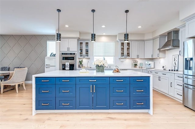 40365 Trenton Ct, Temecula, CA 92591 - kitchen with wall chimney range hood, stainless steel appliances, white cabinetry, light wood finished floors, and recessed lighting