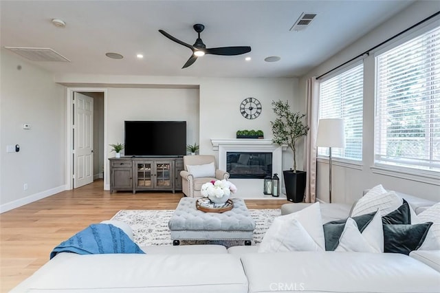 40365 Trenton Ct, Temecula, CA 92591 - living room featuring wood finished floors, ceiling fan, a glass covered fireplace, and recessed lighting