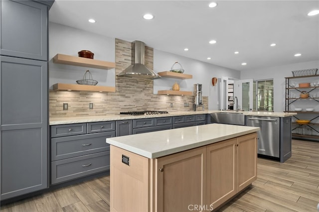 4527 Mockingbird Ln, Banning, CA 92220 - kitchen with appliances with stainless steel finishes, open shelves, wall chimney range hood, a sink, and gray cabinetry