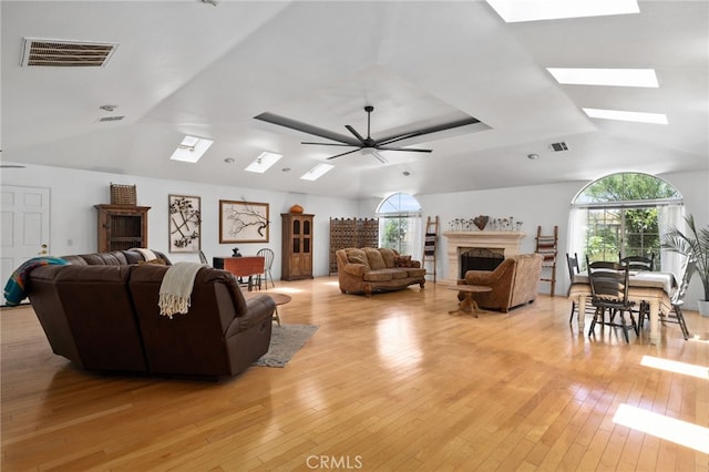 4527 Mockingbird Ln, Banning, CA 92220 - living room with a skylight, ceiling fan, a fireplace, light wood-style floors, and lofted ceiling