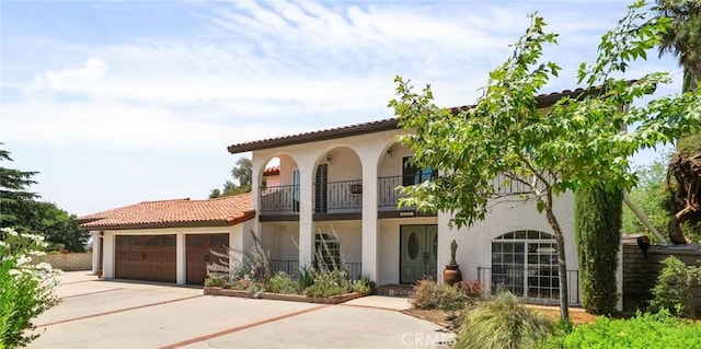 4527 Mockingbird Ln, Banning, CA 92220 - mediterranean / spanish house with stucco siding, a balcony, a garage, and concrete driveway
