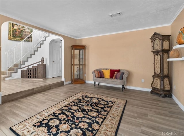4527 Mockingbird Ln, Banning, CA 92220 - living room featuring arched walkways, wood finished floors, ornamental molding, baseboards, and stairway