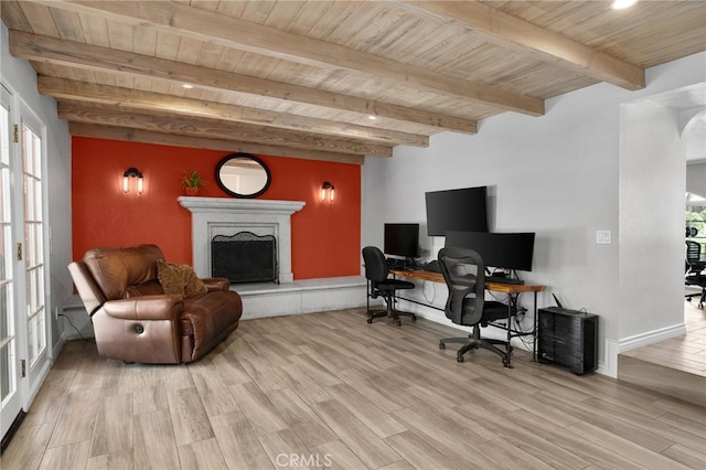 4527 Mockingbird Ln, Banning, CA 92220 - home office featuring wood ceiling with exposed beams, a fireplace with raised hearth, light wood-style flooring, and baseboards